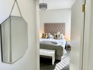 Schlafzimmer mit einem Bett und einem Spiegel in der Unterkunft Gillygate Nest with Free Allocated Parking in York
