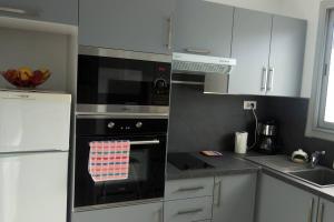 a kitchen with a stove with a towel on the oven at T3 tout confort en front de mer, clim in Saint-Cyprien +5 photos