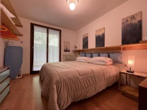 a bedroom with a bed and a large window at 024 Trilocale, Giustino in Giustino