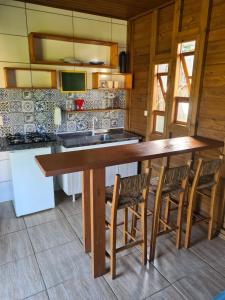 a kitchen with a large wooden table and chairs at Essência da Terra - Cabanas de Temporada in Praia do Rosa