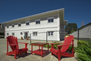 two red chairs and a table in front of a building at Altitude Lodge Hotel in Campos do Jordão