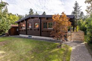 une cabane en bois avec une clôture dans une cour dans l'établissement La Casa Holzwiesen, à Starzach