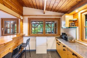 een keuken met houten plafonds en een aanrecht met stoelen bij La Casa Holzwiesen in Starzach