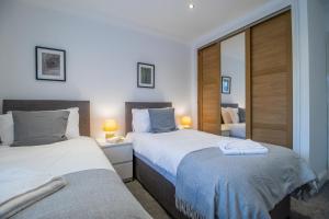 a bedroom with two beds and a mirror at The Brigg in Coatbridge