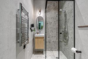 a bathroom with a shower and a sink and a mirror at Molėtairesort in Molėtai