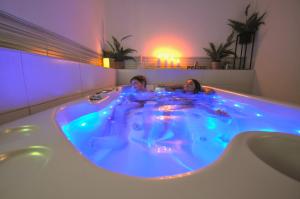 two people in a hot tub with blue lights at Wellness Pension Fulda Černý Důl in Černý Dŭl