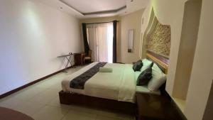 1 dormitorio con 1 cama grande en una habitación en Lux Suites Eden Seafront Apartments, en Shanzu