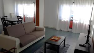 un soggiorno con divano e tavolo di Spazioso appartamento sul lungomare di Nettuno a Nettuno