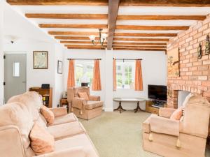 a living room filled with furniture and a brick wall at Pass the Keys Conventional and Homely 3Bed in Alderminster in Stratford-upon-Avon