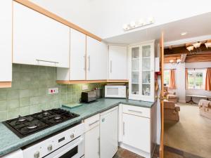 亞芬河畔史特拉福的住宿－Pass the Keys Conventional and Homely 3Bed in Alderminster，厨房配有白色橱柜和炉灶烤箱。