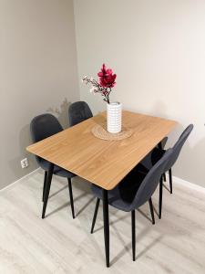 a wooden table with black chairs and a vase with flowers at Tromsdalen Aurora Apartments in Tromsø +12 photos