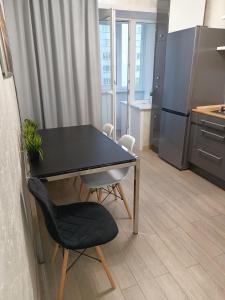 a black table and a chair in a kitchen at Квартира с гостиничным сервисом в центре Петропавловска in Petropavlovsk
