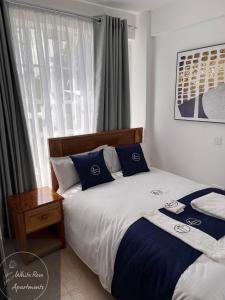 1 Schlafzimmer mit 2 Betten und einem Fenster in der Unterkunft WhiteRose Apartments in Meru