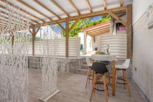 a kitchen and dining area with a table and chairs at Heliconia - Appt avec piscine partagée in Saint-Pierre