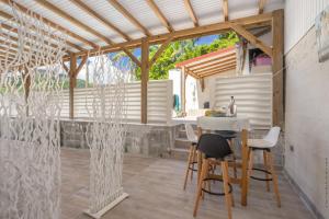 een keuken en een eethoek met een tafel en stoelen bij Heliconia - Appt avec piscine partagée in Saint-Pierre