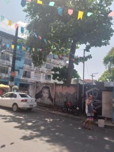 un hombre parado bajo un árbol al lado de una calle en CactusStudio en Salvador