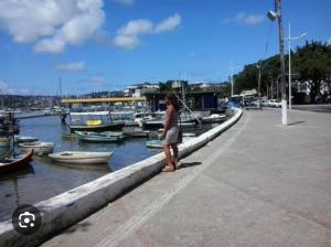a woman standing on a dock with boats in the water at CactusStudio in Salvador
