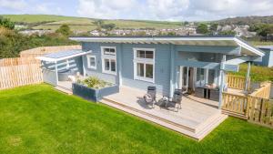 a small blue house with a deck in a yard at Middle Thorne, Great Field Lodges in Braunton