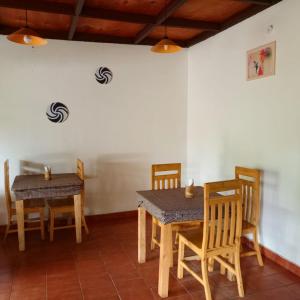 een eetkamer met 2 tafels en stoelen bij COLIBRI TAVERNE Gisenyi in Gisenyi