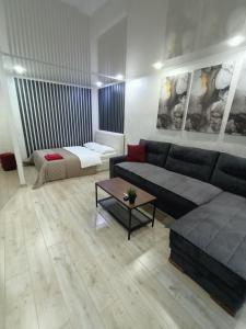 a living room with a couch and a bed at Квартира с гостиничным сервисом в центре Петропавловска in Petropavlovsk