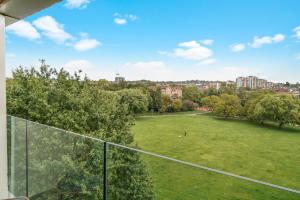 a view of a park from the balcony of a house at Utopian Apartments Kilburn in London