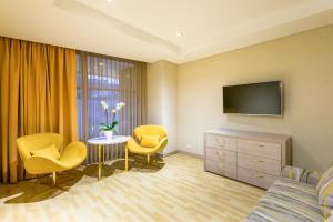 a hotel room with a bed and a tv and chairs at Hotel El Dorado Bogota in Bogotá