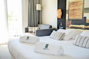 two beds in a hotel room with white sheets and pillows at Thalazur Arcachon in Arcachon