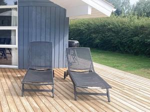 two chairs sitting on a deck next to a house at 10 person holiday home in V ggerl se in Marielyst