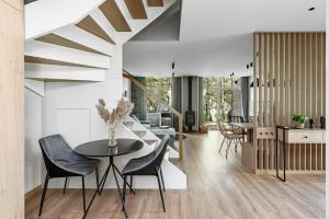 a kitchen and dining room with a table and chairs at Miško Spa namas in Molėtai