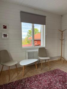 two chairs and a table in a room with a window at Vintergatans Rum in Insjön