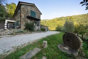 a stone building with a road next to a house at Il Mulino - Appartamento Terra in Borzonasca