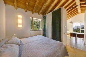 a bedroom with a bed and a table and windows at Il Mulino - Appartamento Terra in Borzonasca
