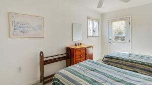 a bedroom with two beds and a dresser and a mirror at Oceanside, 5 BRs, Wild Horses, 600 ft to Beach Access, 4wheel Drive Area, 4x2398, The T House in Knotts Island
