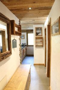 a kitchen with wooden ceilings and a wooden table at Appartement Champex- Lac / La Cabouetta in Champex