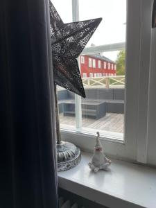 a star sitting on a window sill next to a vase at Vintergatans Rum in Insjön