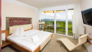 ein Schlafzimmer mit einem weißen Bett und einem großen Fenster in der Unterkunft Hotel AVIVA****s make friends 