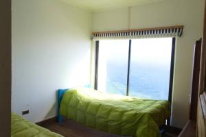 a bedroom with a bed and a large window at Casa Cartagena en acantilado in Cartagena
