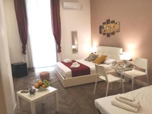 una camera d'albergo con un letto, un tavolo e delle sedie di DOMUS LUIGI LEONE 2 a Napoli