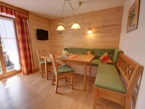 a dining room with a table and a green couch at Hörlhof - Chiemgau Karte in Inzell