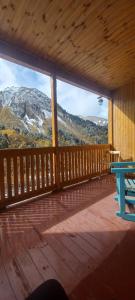 a wooden porch with a view of a mountain at Guest House EMZAR in Adishi