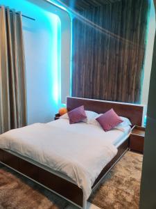 uma cama com almofadas roxas num quarto em Sunset Views Sharifia Villa em Marrakech
