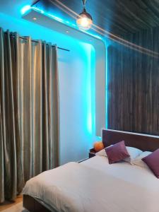 um quarto com uma cama com uma luz azul em Sunset Views Sharifia Villa em Marrakech