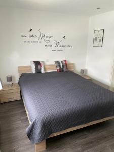 a bedroom with a bed with a black comforter at Ferienwohnung Klatschmohn in Wallscheid