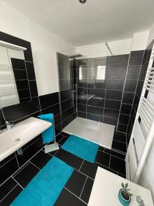 baño con suelo de baldosa azul y negro en Ferienwohnung Klatschmohn, en Wallscheid