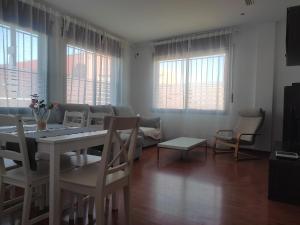 comedor con mesa, sillas y ventanas en Ap4Us B1 - Apartment for us - Sightseeing & Beach At The Best Price, en Badalona