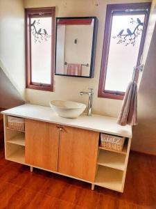 a bathroom with a sink and two windows at Casa Belgrado, te espera. in Oxapampa