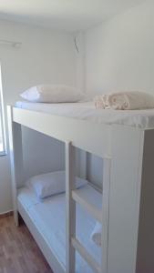 クリチバにあるRESIDENCIAL BOTÂNICOの白い二段ベッドが備わる客室です。