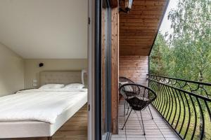 1 dormitorio con 1 cama en el balcón en Pirties Spa namas en Molėtai