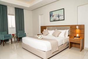 a bedroom with a large bed and a table and chairs at Swiss Spirit Hotel & Suites Dammam Corniche in Dammam