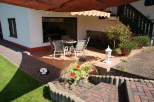 a patio with a table and chairs in a yard at Ferienwohnung Siefert in Mossautal